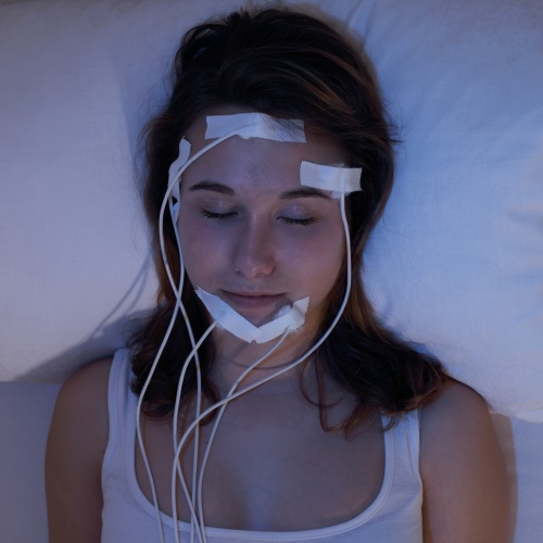 Junge Frau schlafend beim Messen der Gehirnströme