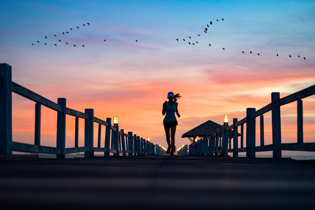 Frau beim Running im Sonnenuntergang
